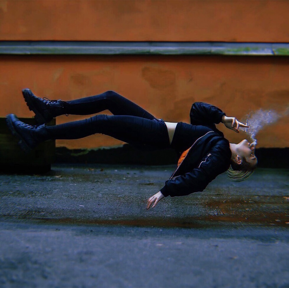 Levitation still, figure floating above wet asphalt